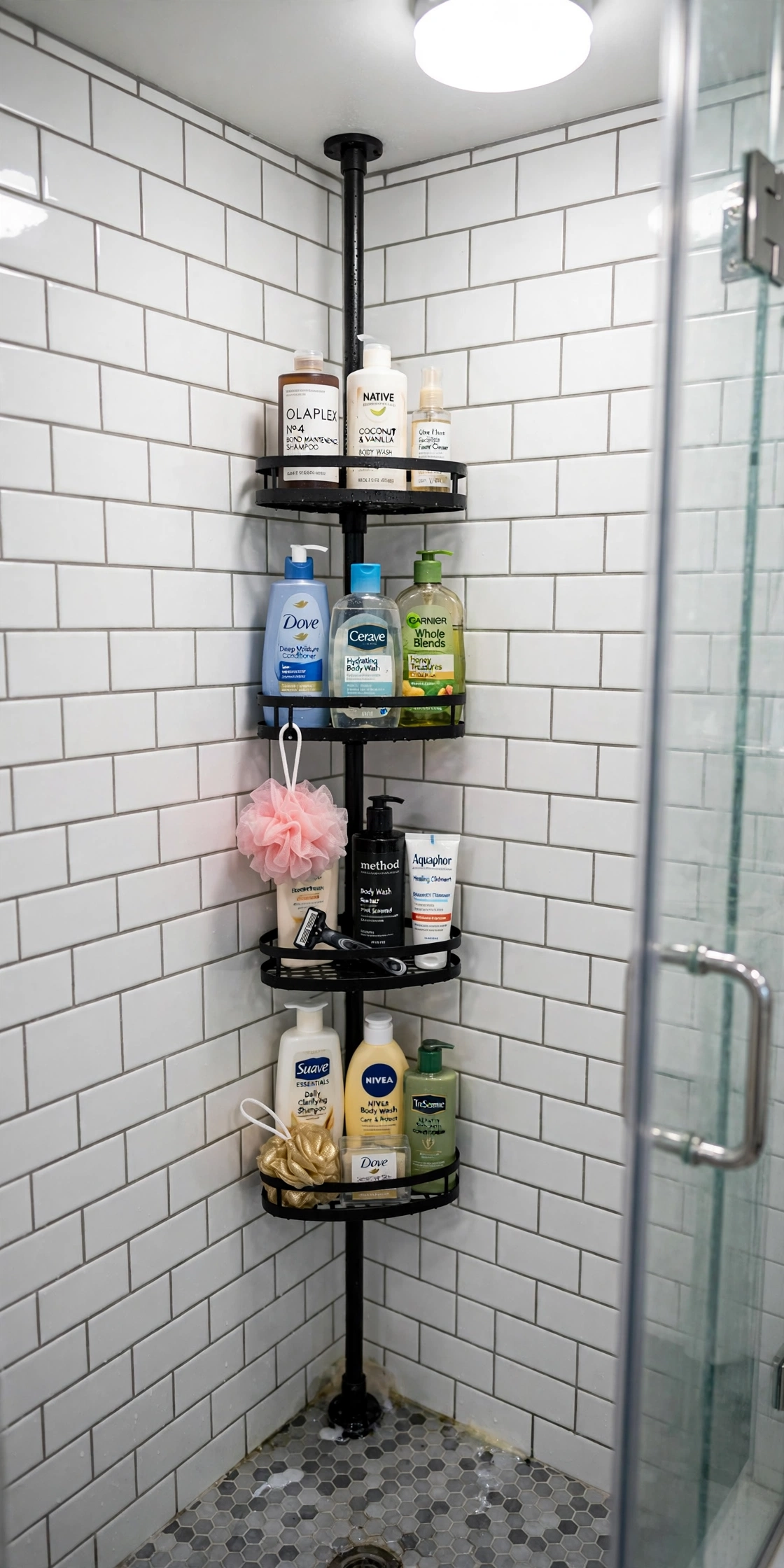 Tension-pole shower caddy holding bottles in the corner of a small shower